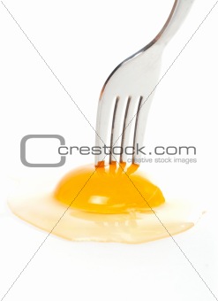 The fork pricking the raw egg