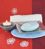 Burning candle and white flowers with soap in a dish