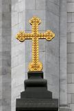 Golden orthodox cross on gray stone background