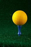 Yellow golfball and blue tee