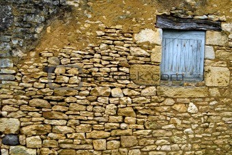 Old yellow stone wall with close window