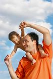 father playing with son over sky background