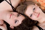 Portrait of the two beauty young women laying on a pillow 2