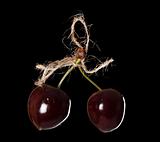 two cherryes tied by rope over black background