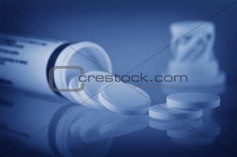 close up of open bottle with few pills