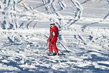 Woman in red and ski traces on snow