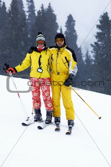 Yong family skiers in yellow and snowfall