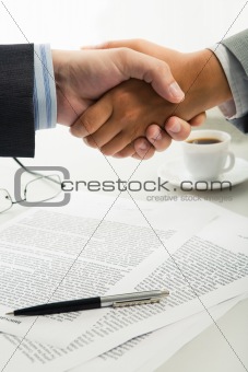 Handshake over workplace 