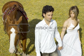 Young couple walking with their horse