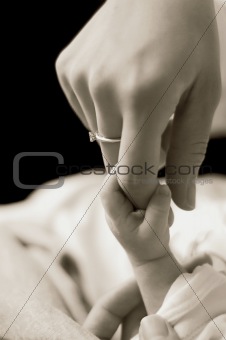Baby holding mum's finger