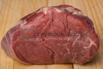 raw meat on a wooden chopping board