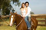 Young couple riding their horse