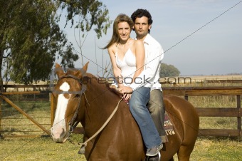 Young couple riding their horse