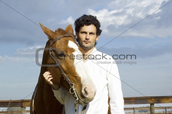 Young man standing with his horse