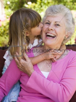 Grandmother getting a kiss from granddaughter