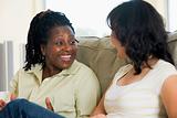 Two women talking in living room and smiling