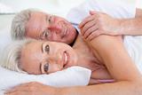 Couple lying in bed together smiling