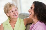 Two women in living room talking and smiling