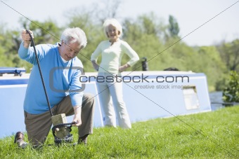 Couple outdoors by lake with boat