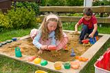 boy and girl playing in sand box
