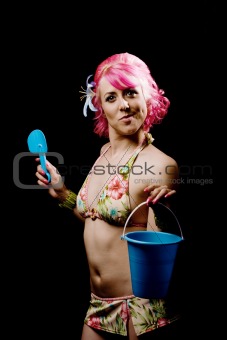 Woman in a bikini on black with pail and shovel