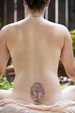 Back of a nude woman meditating