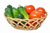 Wicker basket with some tomatoes and cucumbers