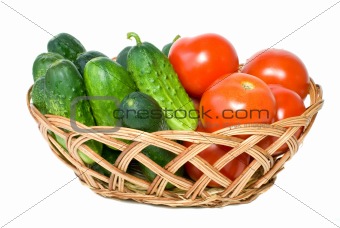 Wicker basket with some tomatoes and cucumbers