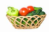 Basket with some cucumbers, tomatoes and sweet peppers