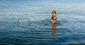 young beautiful girl in provocative dress standing in water
