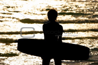 silhouette of young girl with kite board at sunset sea