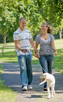 Young Couple Walking Dog