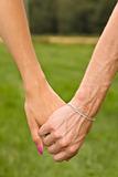 Couple holding hands in meadow close up