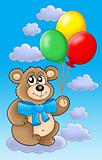 Teddy bear with color balloons on blue sky.