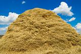 stack of straw on a background blue sky with clouds
