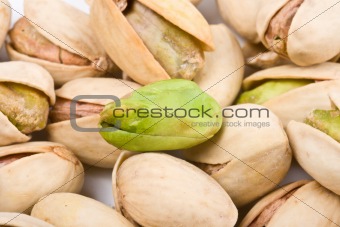 Several pistachio nuts naked and in shell close up