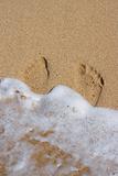 Wave surging on footpints on sand
