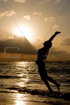 Girl jumping on sunrise at the beach