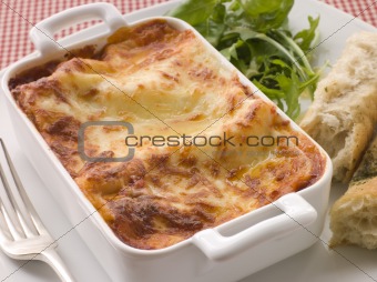 Dish of Lasgane with Salad Leaves and Italian Bread