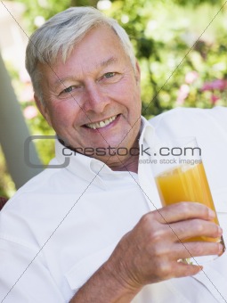 Senior man enjoying glass of juice
