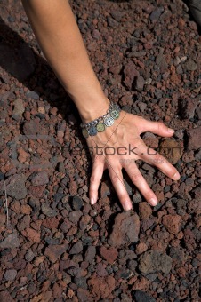 hand on volcanic stones