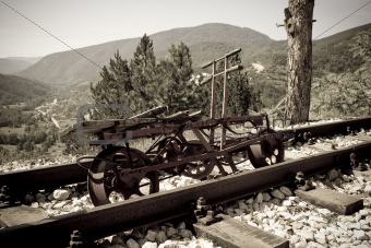 rusting railroad bicycle next to rail tracks