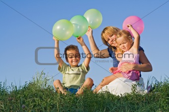 Kids and woman with balloons outdoors