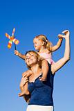 Little girl and woman with a pinwheel toy outdoors