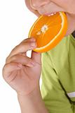 Boy eating orange slice - closeup