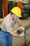 Metal Worker Measures Pipe