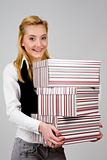 Smiling young woman with stack of boxes