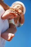 baby on parent's hands, focus on feet