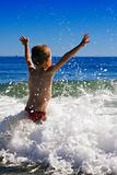 young child playing in the waves