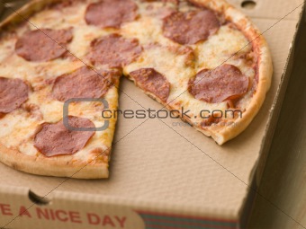 Pepperoni Pizza in a Take Away Box with a Slice Taken